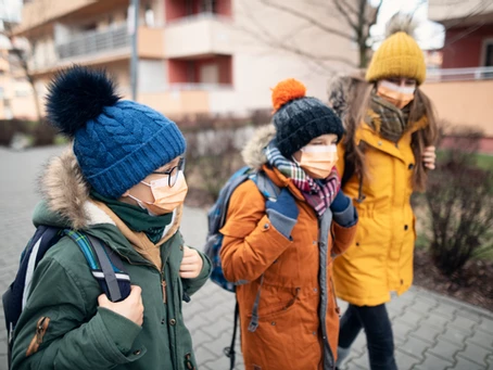 3 kinderen op weg naar school met mondmasker op